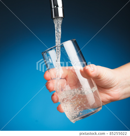 hand pouring a glass of water from filter tap hand pouring a glass of water from filter tap 85255022