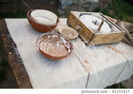 The ancient handmill or quern stone, grinds the grain into flour. Old handmade grinding stones. 85255817