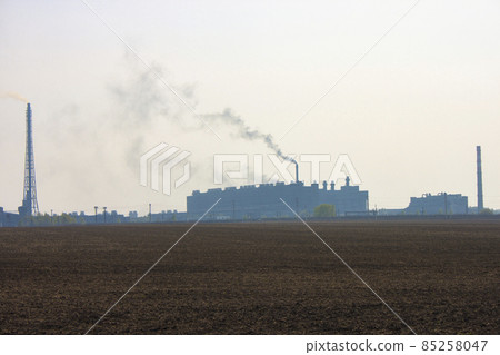 Industrial landscape. Silhouette of a factory with chimneys against a gloomy gray sky 85258047