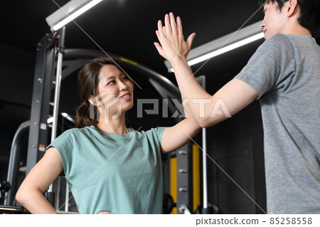 高五的男人和女人在健身房做雙人訓練 高五的男人和女人在健身房做雙人訓練 85258558