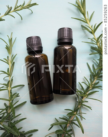 Two aroma oil bottles and rosemary leaves 85259263