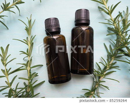 Two aroma oil bottles and rosemary leaves Two aroma oil bottles and rosemary leaves 85259264