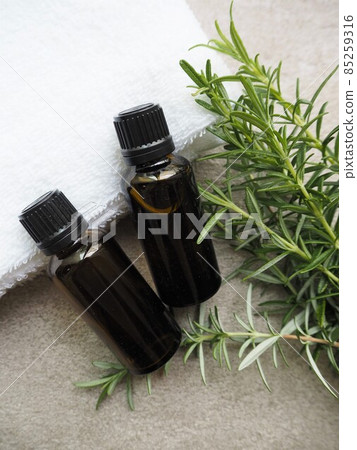Two aroma oil bottles and rosemary leaves 85259316