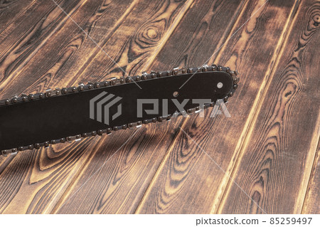 Chain saw on wood on a wood background Chain saw on wood on a wood background 85259497