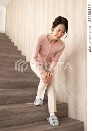 Senior woman descending stairs 85260429