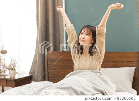 Young woman getting up from bed 85260505