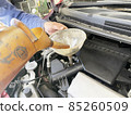 Oil change work by car mechanic watering can 85260509