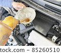 Oil change work by car mechanic watering can 85260510