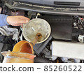Oil change work by car mechanic watering can 85260522
