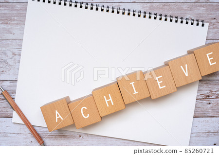 Building blocks, pens and notebooks with "ACHIEVE" written on them 85260721