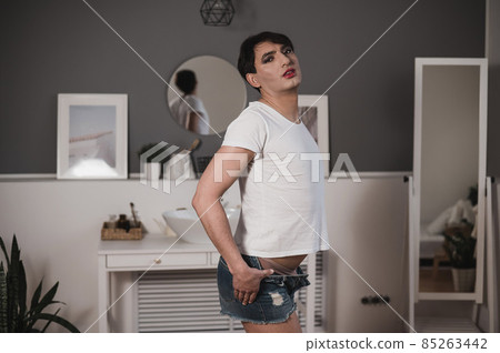 Caucasian gay man takes off his shorts erotically. Gender diversity. 85263442