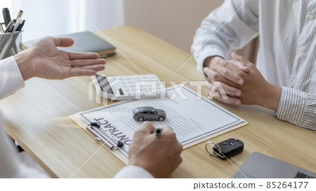 Selling cars, Car dealership or sales manager offers the sale of a car and explains the terms of signing a car purchase and insurance contract, Finance and after-sales service concept.  85264177