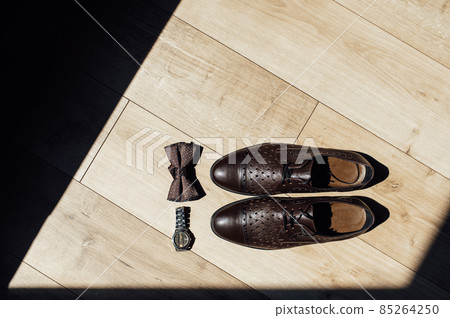 Close up of modern man accessories. Black bowtie, leather shoes and watches 85264250