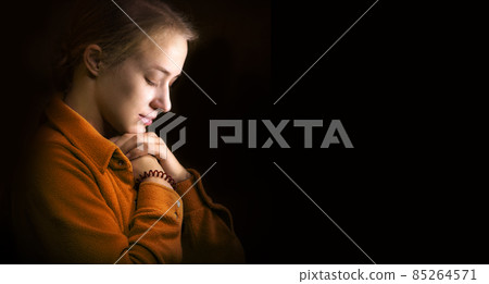 Young woman praying Young woman praying 85264571
