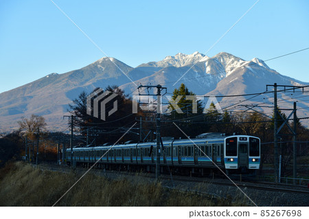 Trains going up the Chuo Main Line at dusk with Yatsugatake in Nagasaka-cho, Hokuto City 85267698