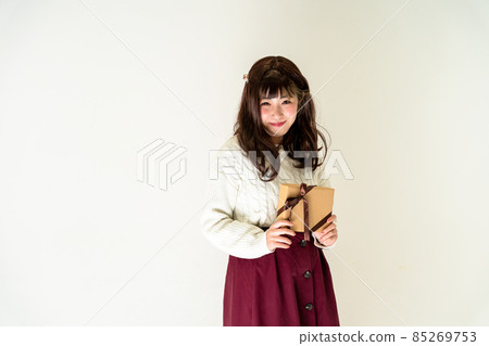 Woman standing with a present Woman standing with a present 85269753