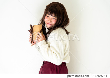 Woman standing with a present Woman standing with a present 85269761