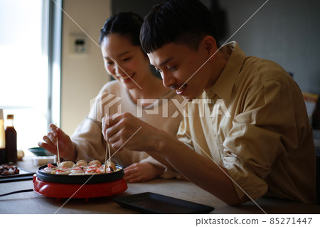 A couple making takoyaki at home A couple making takoyaki at home 85271447