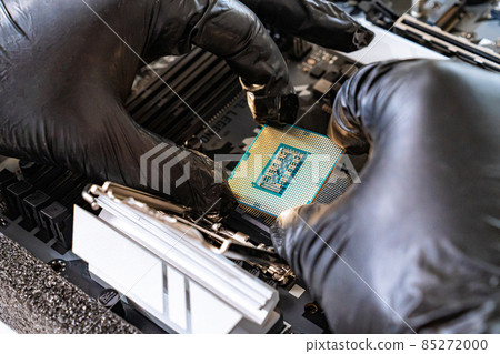 hand of repairman wearing black gloves with a processor. computer workshop. 85272000