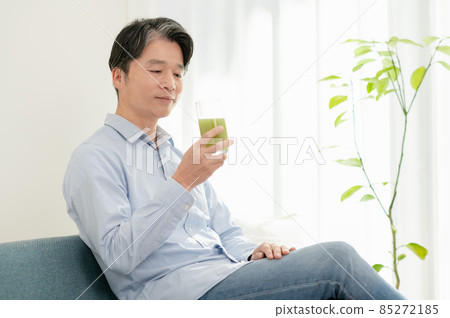 Middle-aged man who cares about his health and drinks green juice Middle-aged man who cares about his health and drinks green juice 85272185