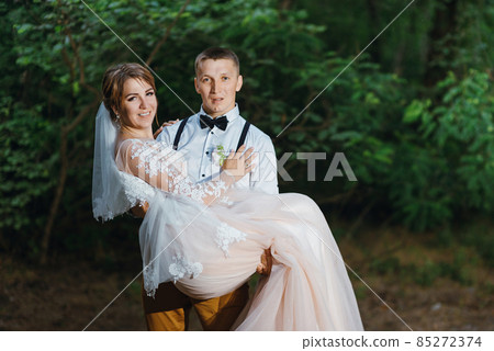 Sensual portrait of a young couple. Wedding photo outdoor. Wedding shot of bride and groom in park. Just married couple embraced. 85272374