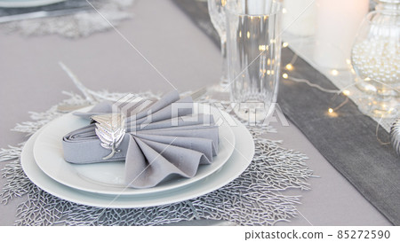 Beautiful table setting with Christmas decorations. Silver colors Beautiful table setting with Christmas decorations. Silver colors 85272590