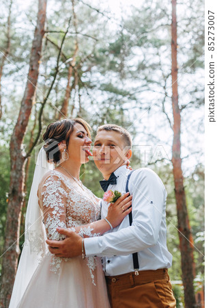 Sensual portrait of a young couple. Wedding photo outdoor. Wedding shot of bride and groom in park. Just married couple embraced. Sensual portrait of a young couple. Wedding photo outdoor. Wedding shot of bride and groom in park. Just married couple embraced. 85273007