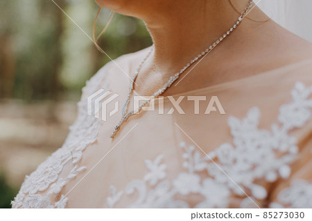 Beautiful unrecognizable bride - closeup shot. beautiful pearls on neck Bride, wedding accessories. Beautiful bride adornment. 85273030