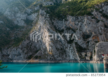 The concept of eco-tourism and active recreation. National Park. Mountain Emerald lake in the wooded mountains. Sunny day in autumn 85273954