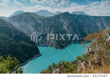 The concept of eco-tourism and active recreation. National Park. Mountain Emerald lake in the wooded mountains. Sunny day in autumn 85274347