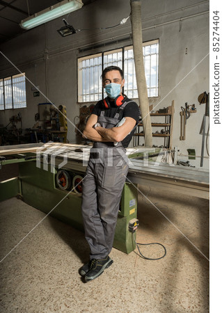 Worker looking at camera smiling in a factory. Worker looking at camera smiling in a factory. 85274404