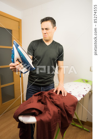 Man who does not know how to iron clothes. Man who does not know how to iron clothes. 85274555