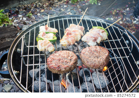 Bacon wrapped with hamburger steak baked on a barbecue stove and skewered angler fish 85274572
