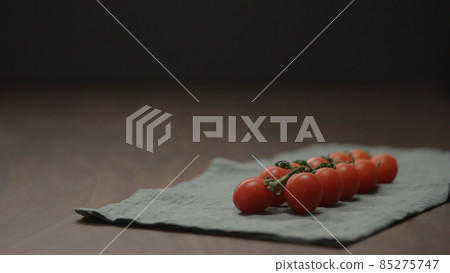 cherry tomatoes on a branch on linen cloth 85275747