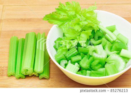 Fresh Chopped Celery Slices in White Bowl with Celery Sticks on Bamboo Cutting Board Fresh Chopped Celery Slices in White Bowl with Celery Sticks on Bamboo Cutting Board 85276213