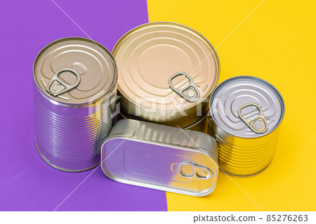 A Group of Stacked Tin Cans with Blank Edges on Split Yellow and Violet Background A Group of Stacked Tin Cans with Blank Edges on Split Yellow and Violet Background 85276263