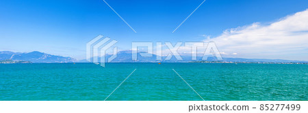 Panorama of Garda Lake azure turquoise water with view of Monte Baldo mountain range 85277499