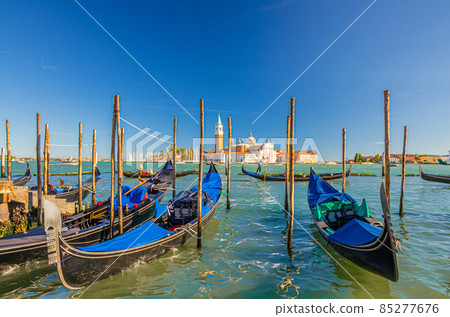 Gondolas moored docked on water in Venice Gondolas moored docked on water in Venice 85277676