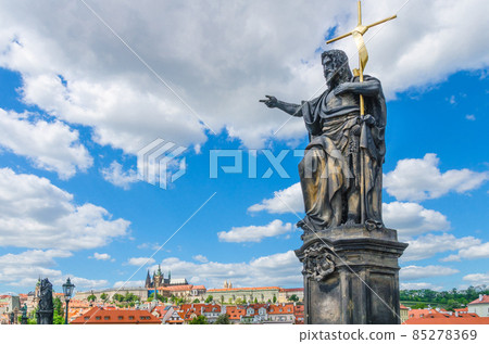 Saint John the Baptist statue on Charles Bridge Karluv Most over Vltava river with Prague Castle 85278369