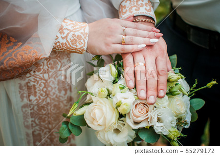 Bride and groom hands with flower bouquet 85279172