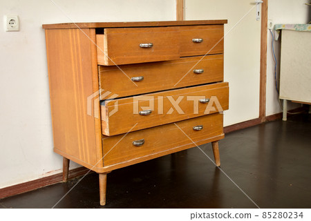 An old brown chest of drawers with metal handles. An old brown chest of drawers with metal handles. 85280234
