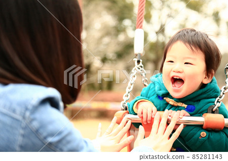 Parents and children playing on a swing 85281143