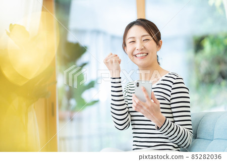 一個操作智能手機的年輕女子 一個操作智能手機的年輕女子 85282036
