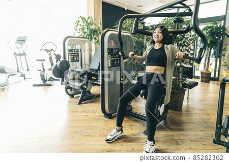 A woman who trains at a sports gym (pectoral muscles / smile) A woman who trains at a sports gym (pectoral muscles / smile) 85282302