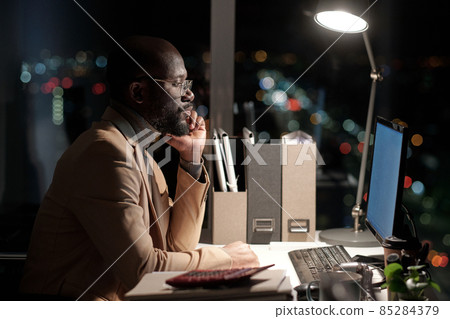 Side view of serious businessman looking at computer screen 85284379