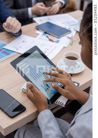 Hand of young African businesswoman scrolling in tablet Hand of young African businesswoman scrolling in tablet 85284493