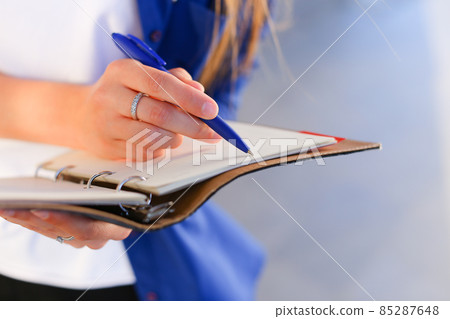 Girl holds in hands diary, notebook with sheets and pen and writes in notebook. Girl holds in hands diary, notebook with sheets and pen and writes in notebook. 85287648