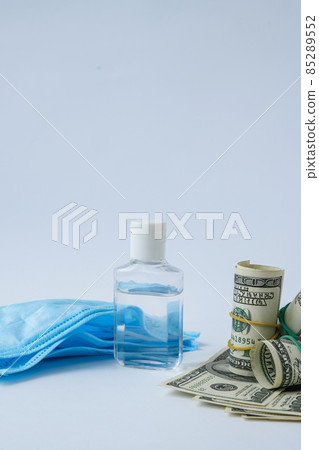 Stack of cash dollars and medical mask sanitizer antiseptic. The concept of medical expensive medicine. Copy space for text. Health Life insurance. vaccination costs. Covid-19 crimes Stack of cash dollars and medical mask sanitizer antiseptic. The concept of medical expensive medicine. Copy space for text. Health Life insurance. vaccination costs. Covid-19 crimes 85289552