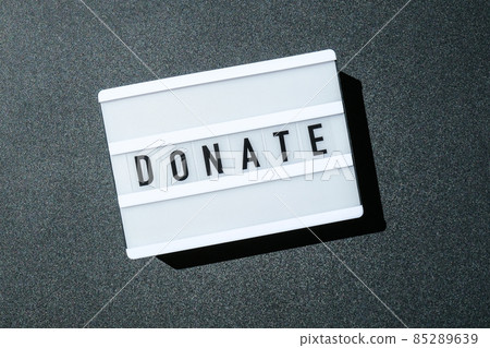 Lightbox board on a black background with the words DONATE in black letters. Lightbox board on a black background with the words DONATE in black letters. 85289639