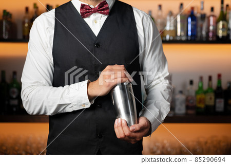 Cool professional bartender making a cocktail, shaking a cocktail shaker. Authentic barman making Cool professional bartender making a cocktail, shaking a cocktail shaker. Authentic barman making 85290694